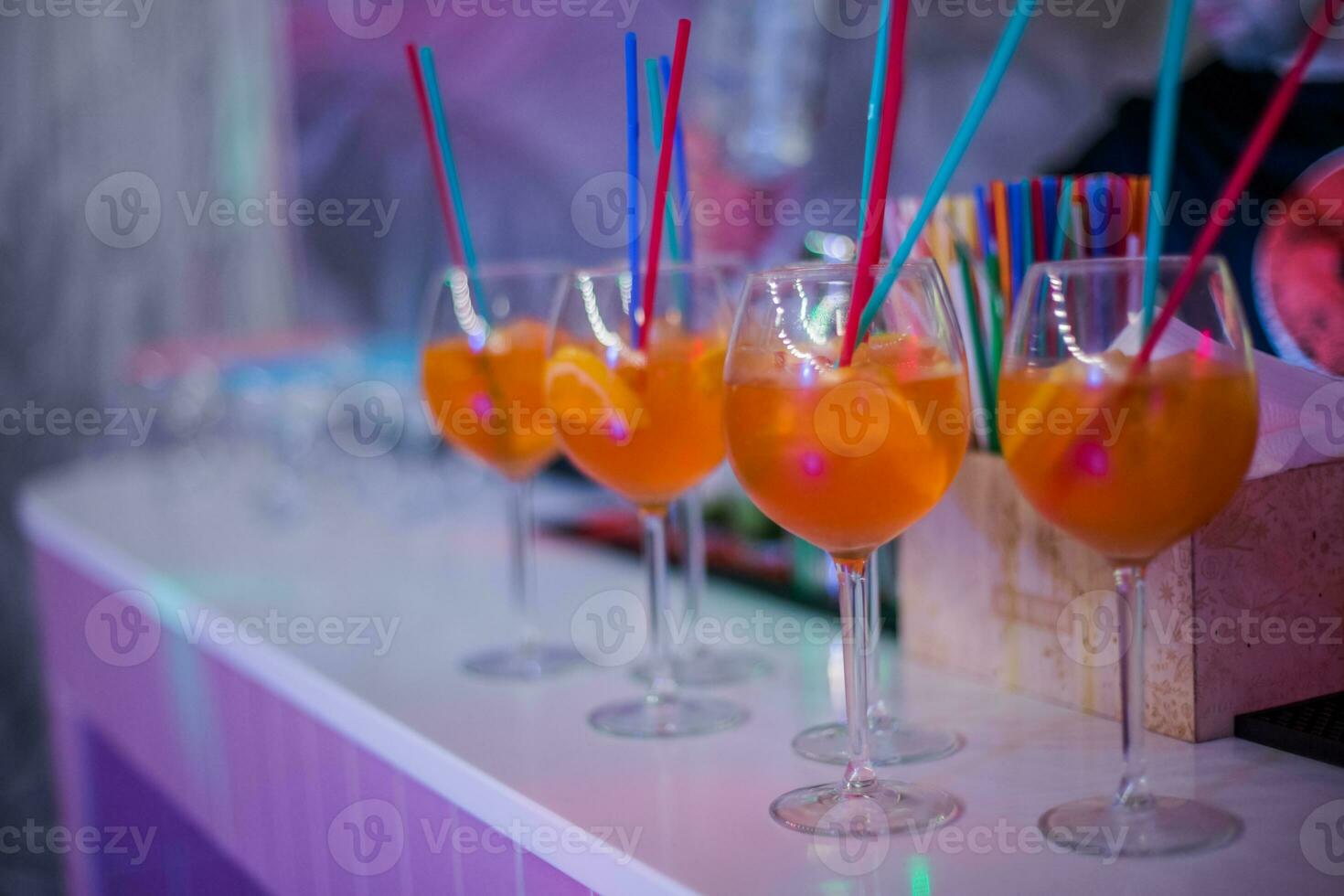 Bocals hanging on the bar. Wine glasses in a restaurant at a party. Light music and laser show in a bar or cafe. photo