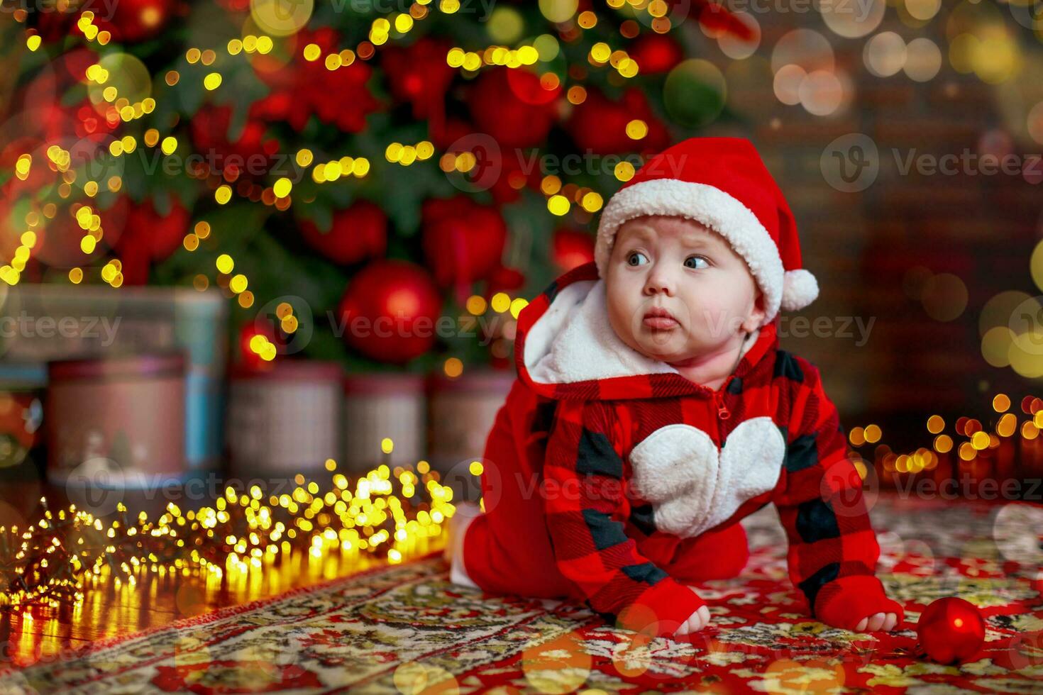 Little six month old baby dressed as Santa Claus. Background for christmas card. The child looks down at the place for inscription. photo