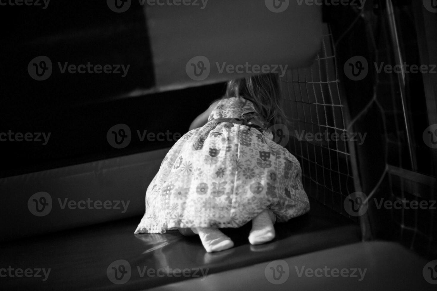 A girl in a long white elegant dress crawls into a maze in the p photo