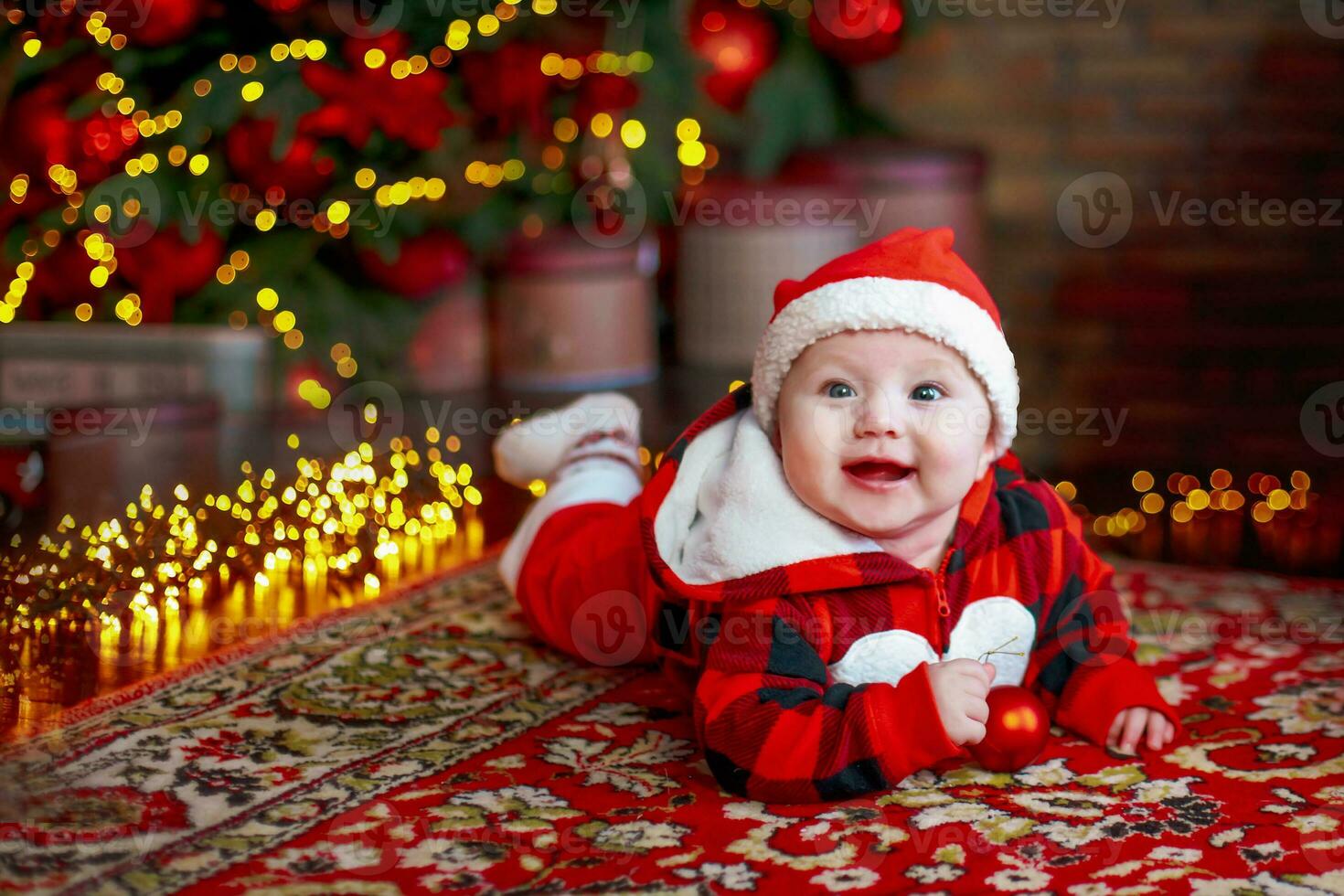Little six month old baby dressed as Santa Claus. Background for christmas card. The child looks down at the place for inscription. photo