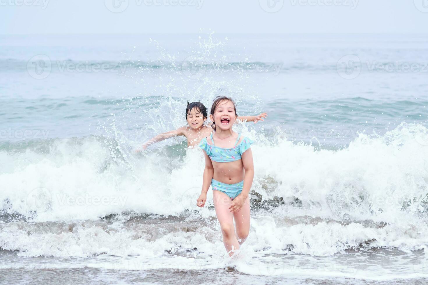 A boy and a girl are having fun playing in the sea. photo