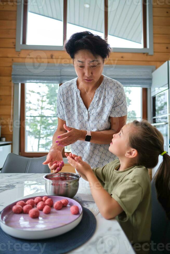 abuela y nieta preparando albóndigas. foto