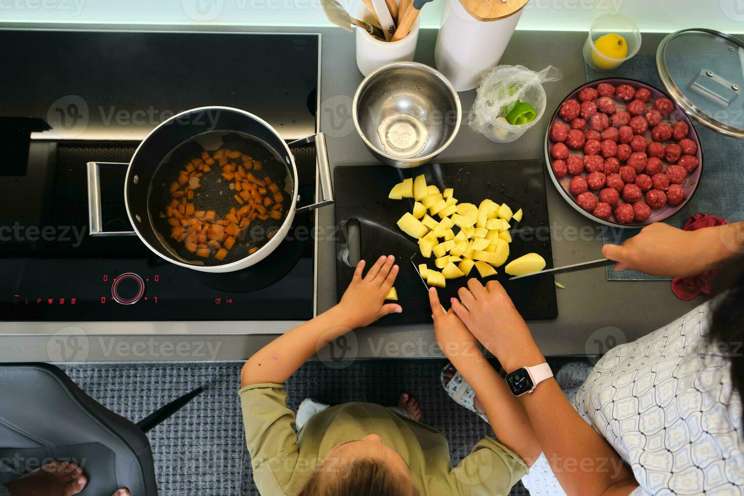 Grandmother and granddaughter are preparing soup. photo