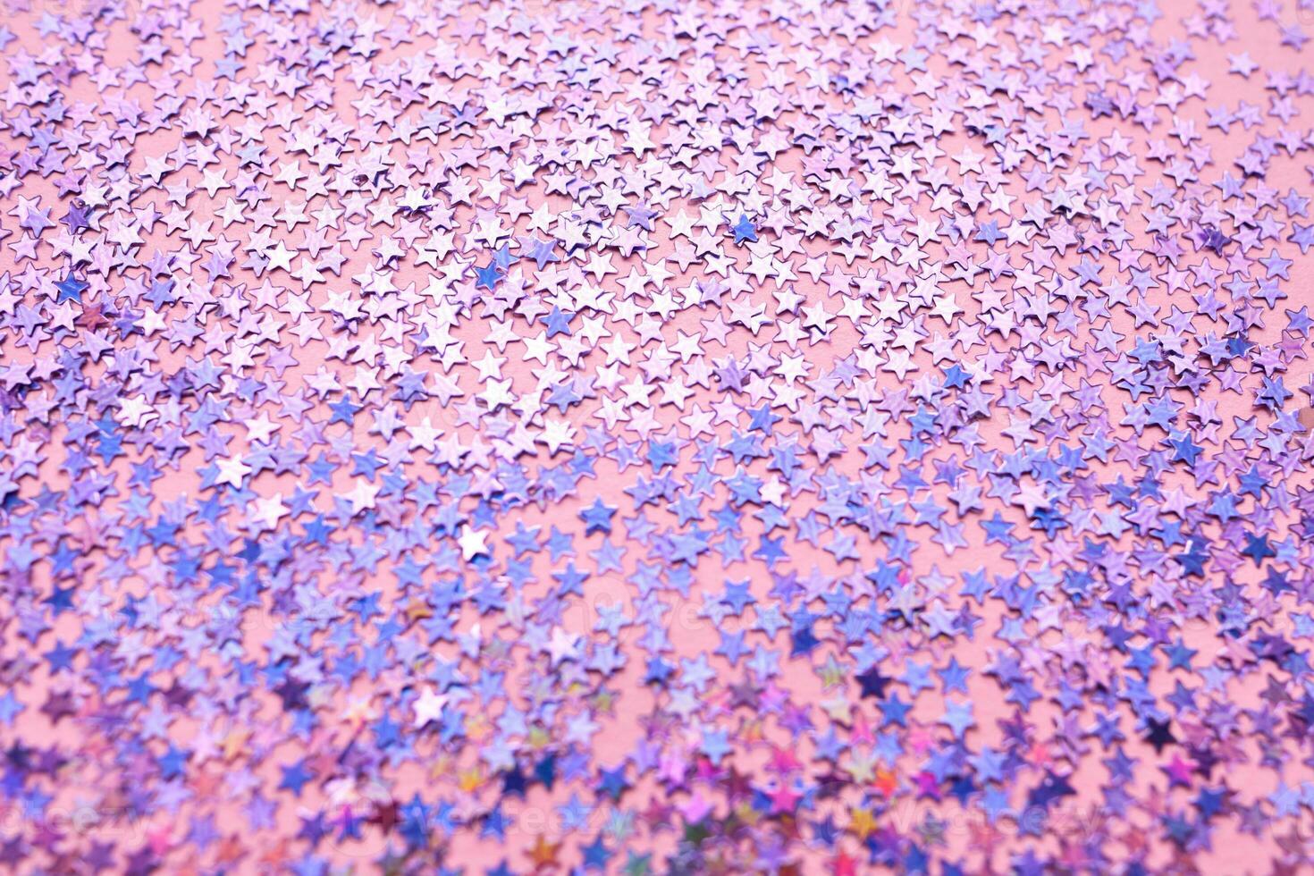 Purple sparkles on a pink background. photo