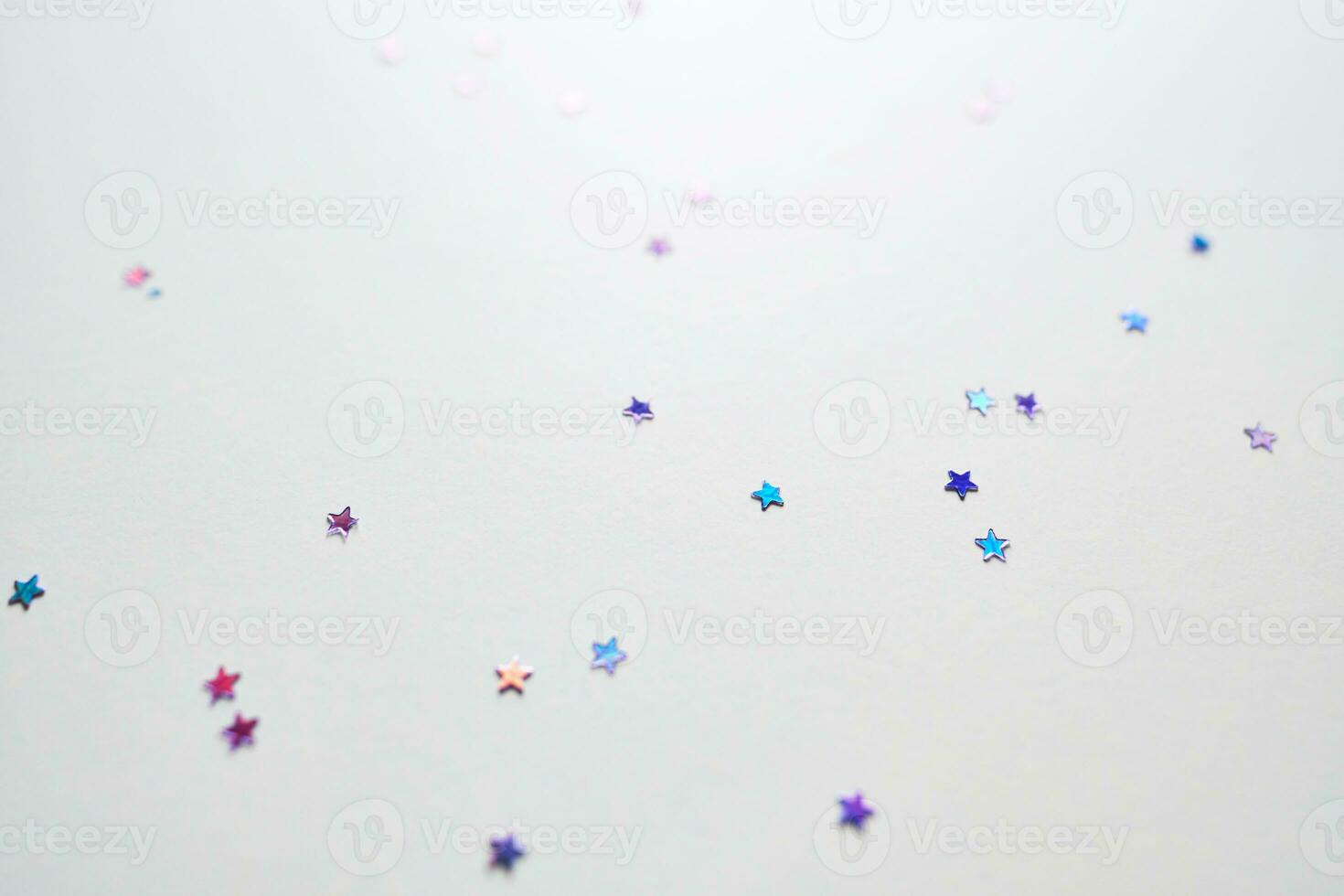 Purple sparkles in the shape of stars on a white. photo