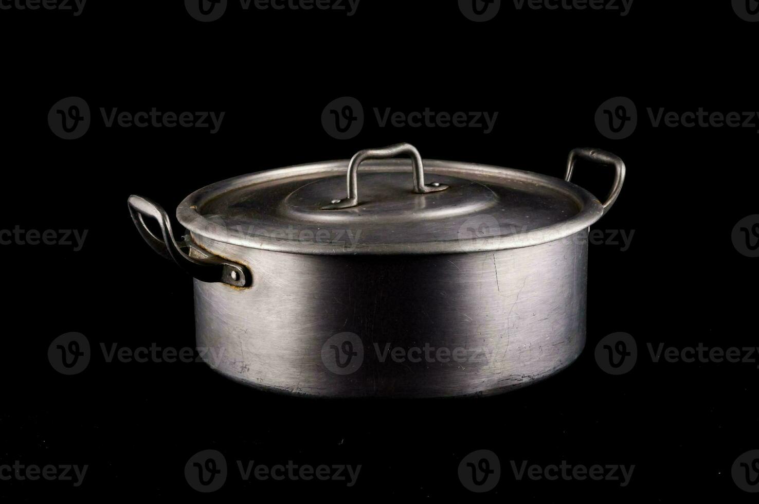 an old metal pot on a black background photo