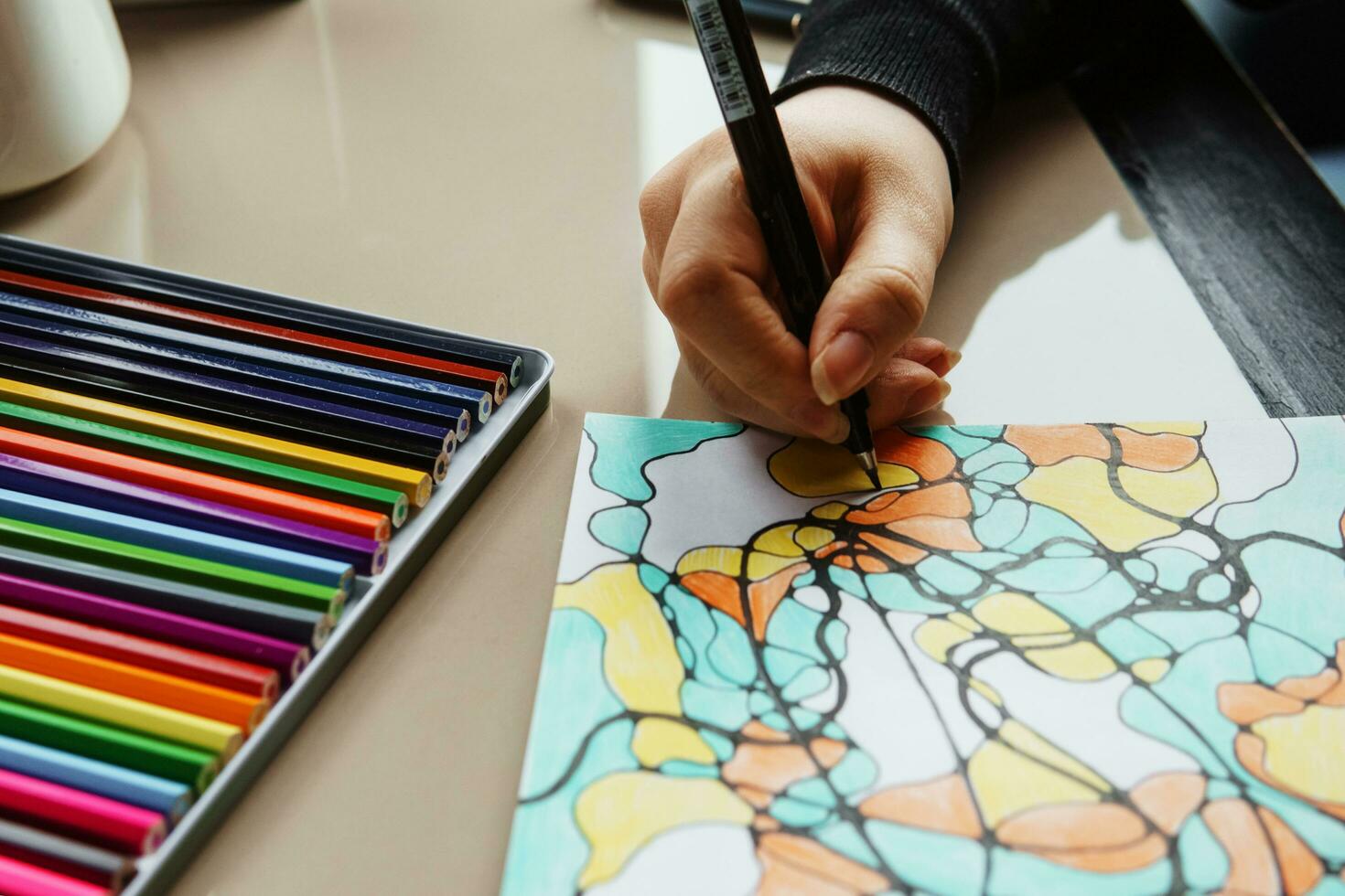 TVER, RUSSIA - FEBRUARY 11, 2023. a young woman draws neurography at a table at a psychological session, a neurographic resunok with a pencil to remove oranicheniy, art therapy. photo