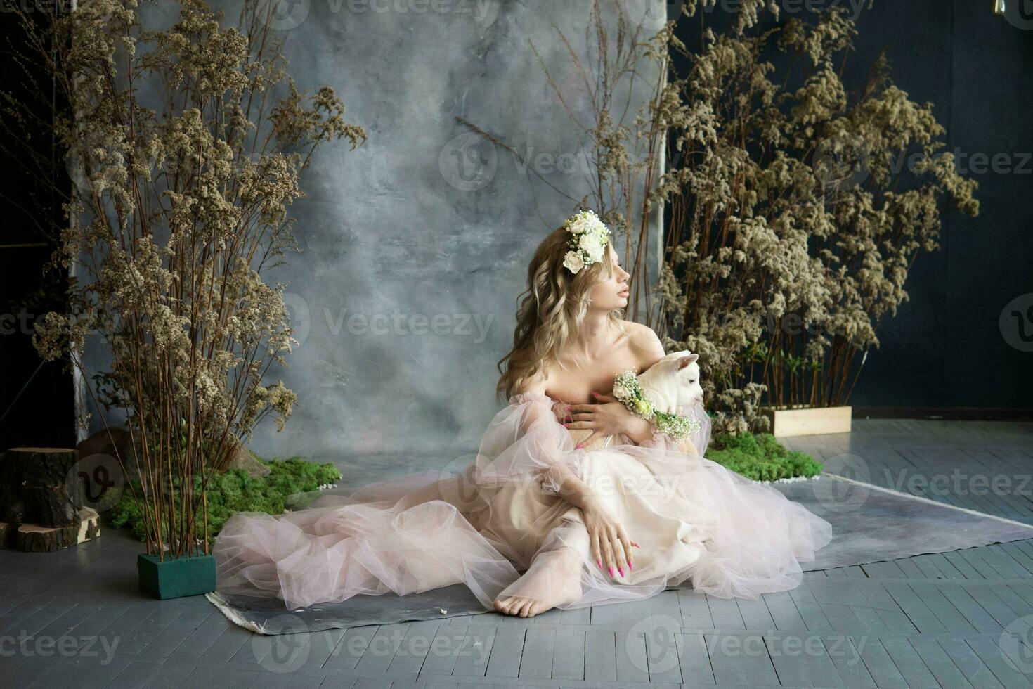 A young blonde woman in an airy pink dress with a white kid. Spring portrait of a woman. photo