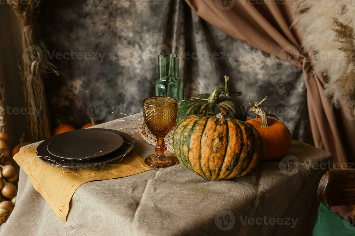 Autumn interior. a table covered with dishes, pumpkins, a relaxed composition of Japanese pampas grass. Interior in the photo Studio. Close - up of a decorated autumn table.