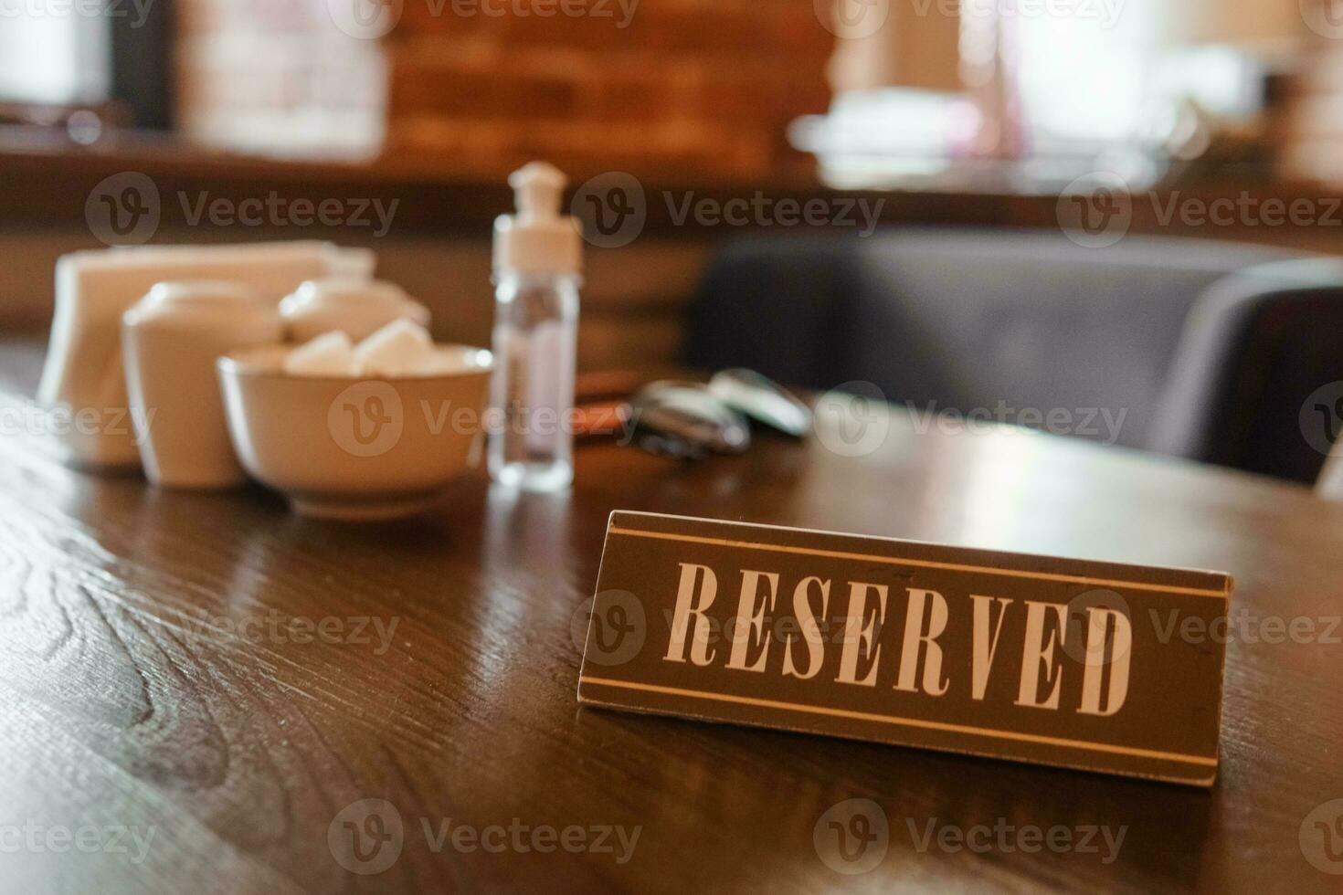 A sign with the inscription - reserved, standing on a wooden table in the restaurant photo