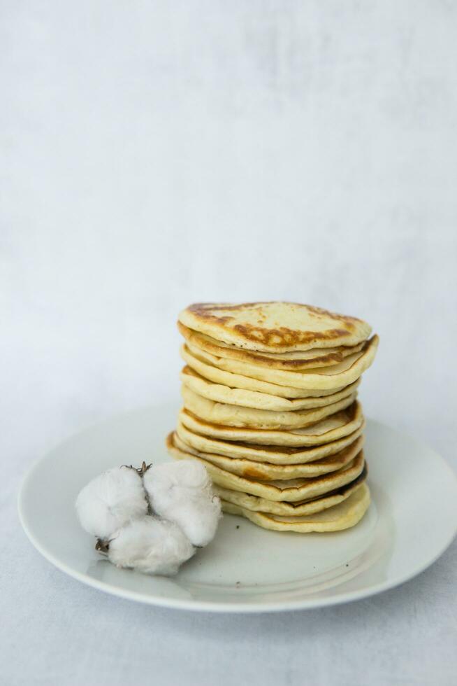 Homemade pancakes on kefir on a white plate. Cooking at home, home-cooked food. Space for text. photo