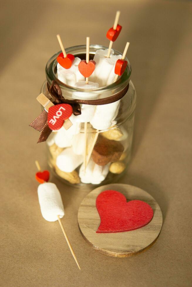 sweet gift for Valentine's Day with your own hands. A gift for the holiday made of heart-shaped candies and marshmallows photo