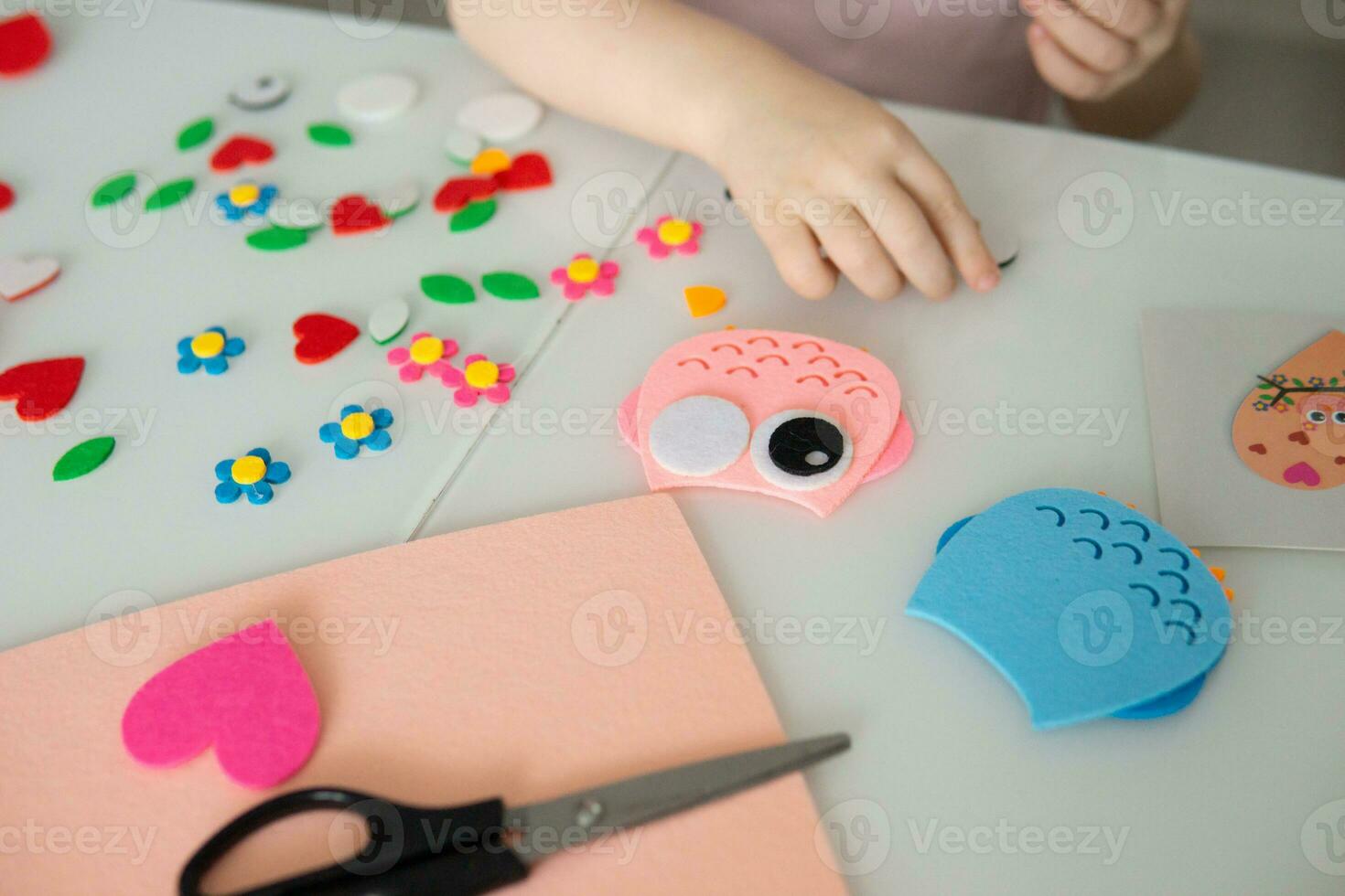 A blogger girl makes a felt craft for Valentine's Day in the shape of a heart. The concept of children's creativity and handmade. photo