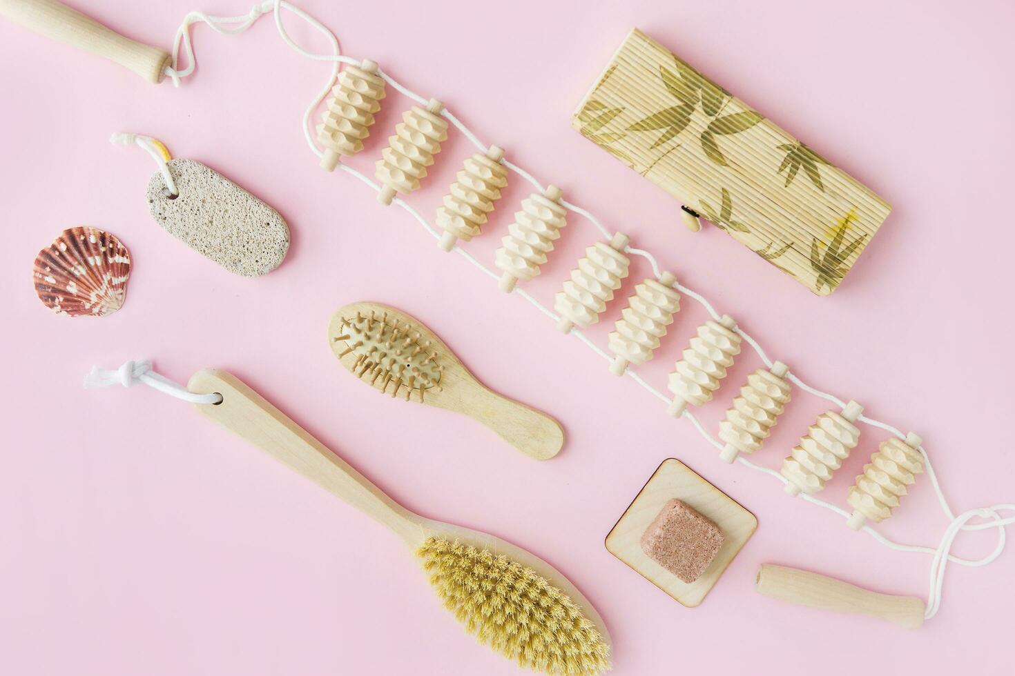 Concept of Spa-cosmetic and cosmetic procedures. Spa-sea salt, wooden comb, massager, anti-cellulite massage brush on a pink background. The concept of a waste-free lifestyle. photo