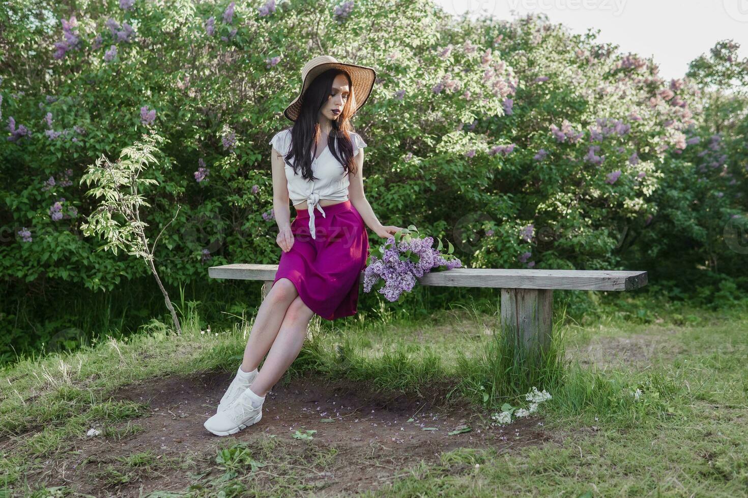 A fashionable girl with dark hair, a spring portrait in lilac tones in summer. Bright professional makeup. photo