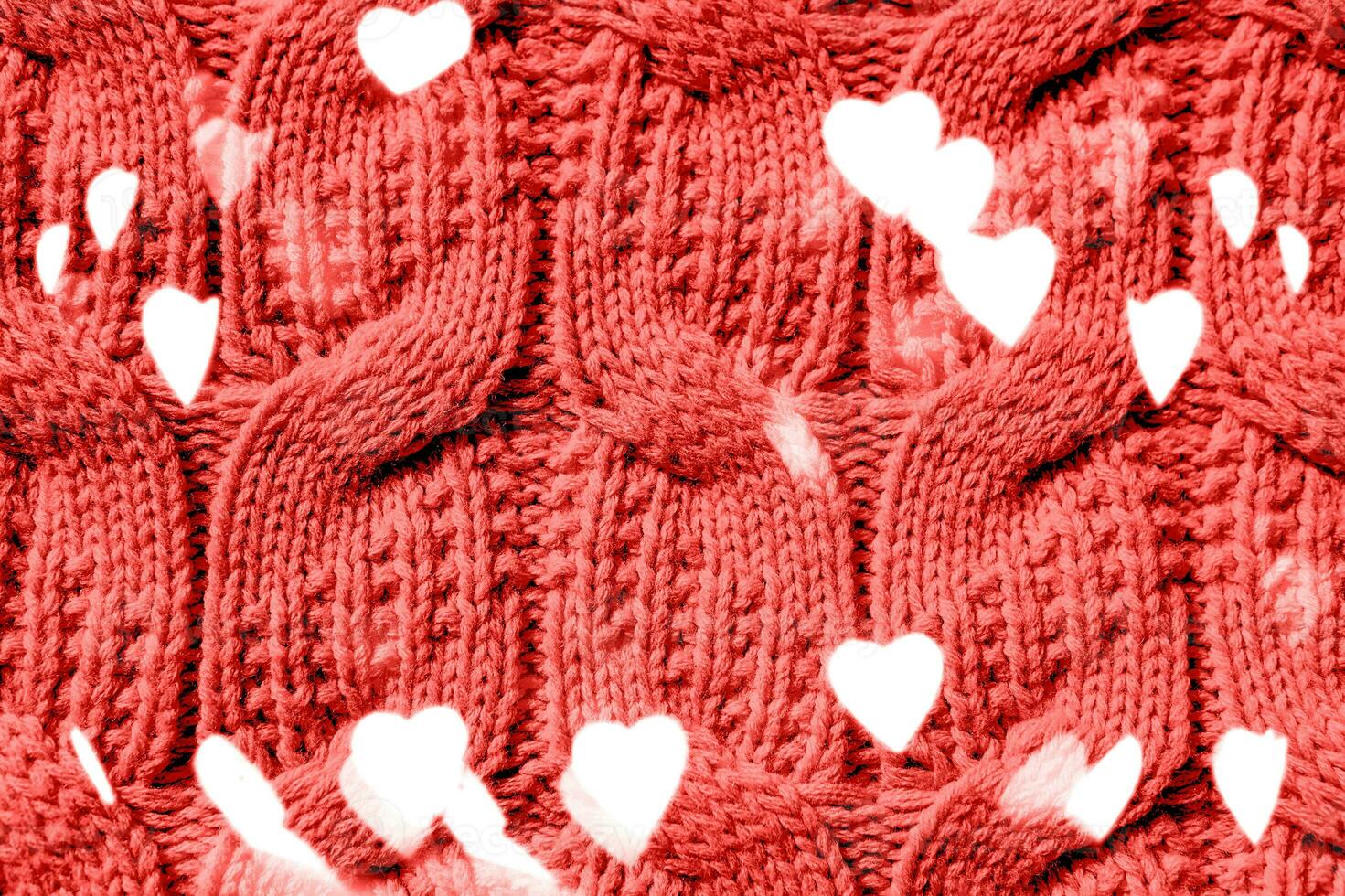 Beautiful handmade knitted repeating pattern. Festive bokeh background in the form of hearts for Valentine's Day photo