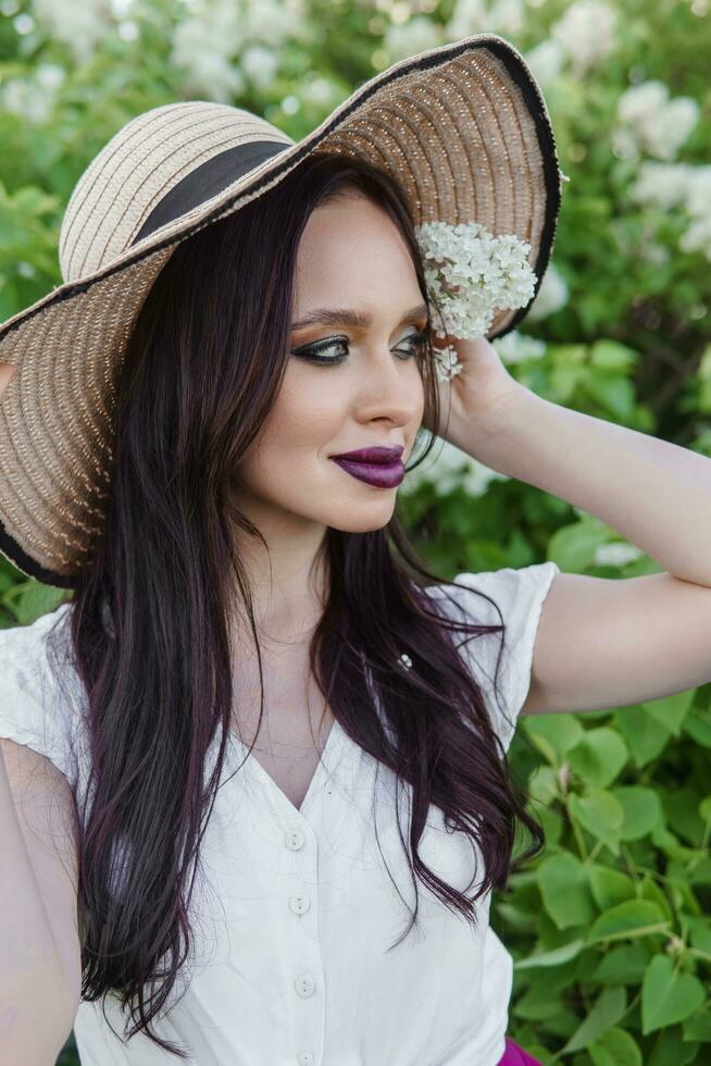 un de moda niña con oscuro cabello, un primavera retrato en lila tonos en verano. brillante profesional constituir. foto