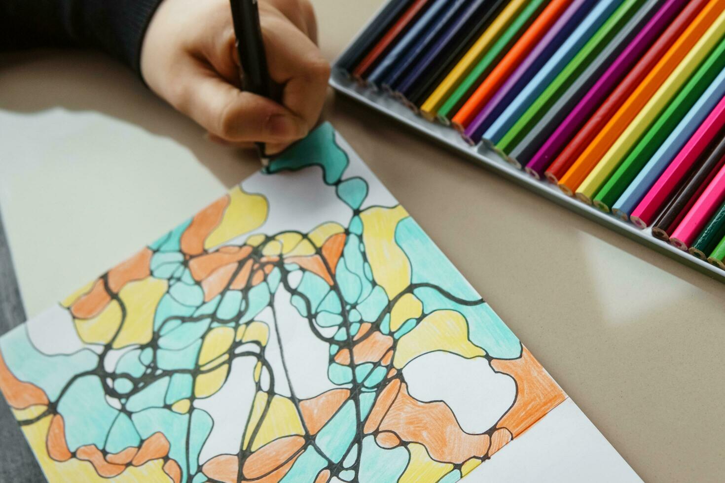 TVER, RUSSIA - FEBRUARY 11, 2023. a young woman draws neurography at a table at a psychological session, a neurographic resunok with a pencil to remove oranicheniy, art therapy. photo