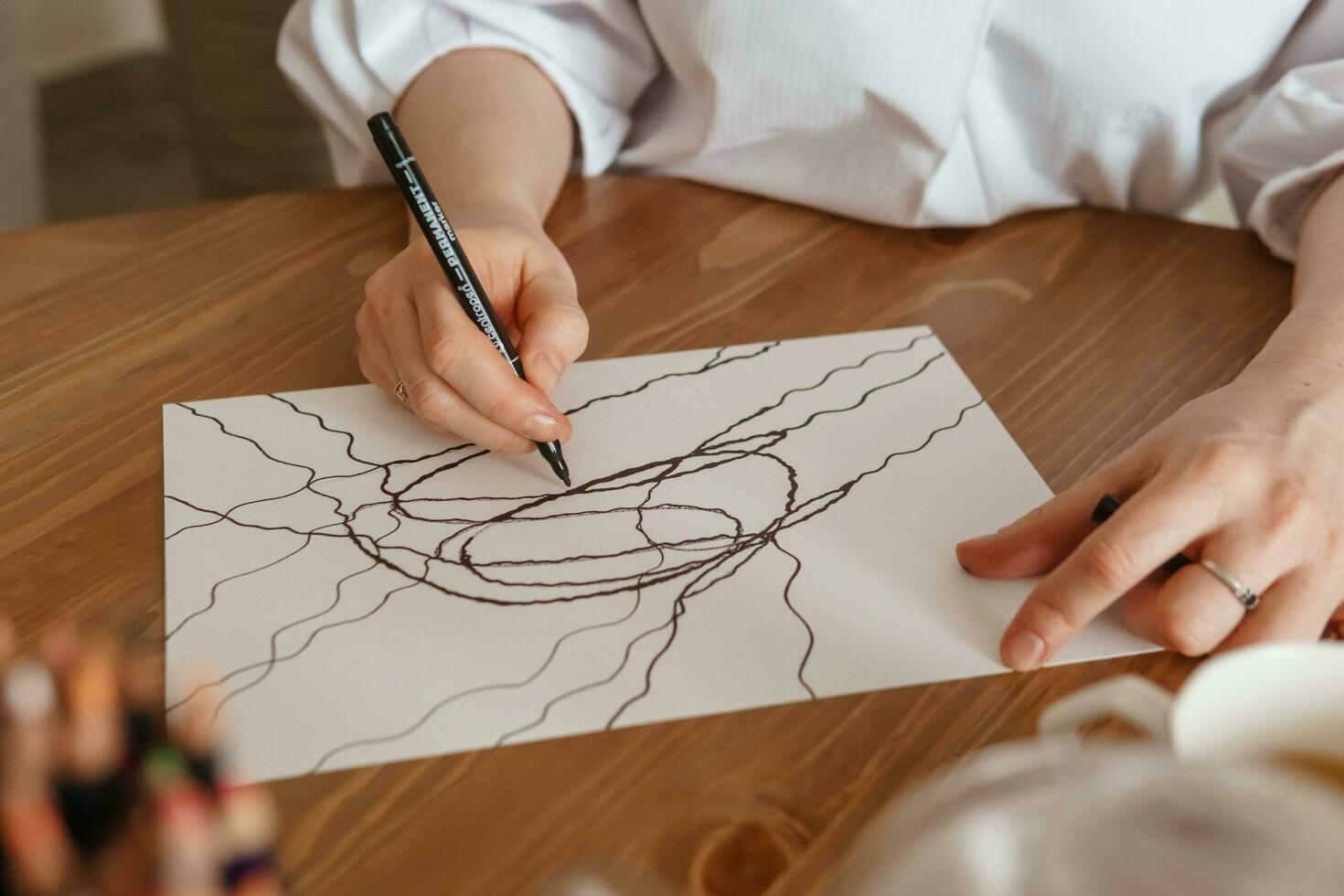 TVER, RUSSIA - FEBRUARY 25, 2023. Woman draws neurographics at table at a psychological session, neurographic pencil drawing to remove restrictions, art therapy photo