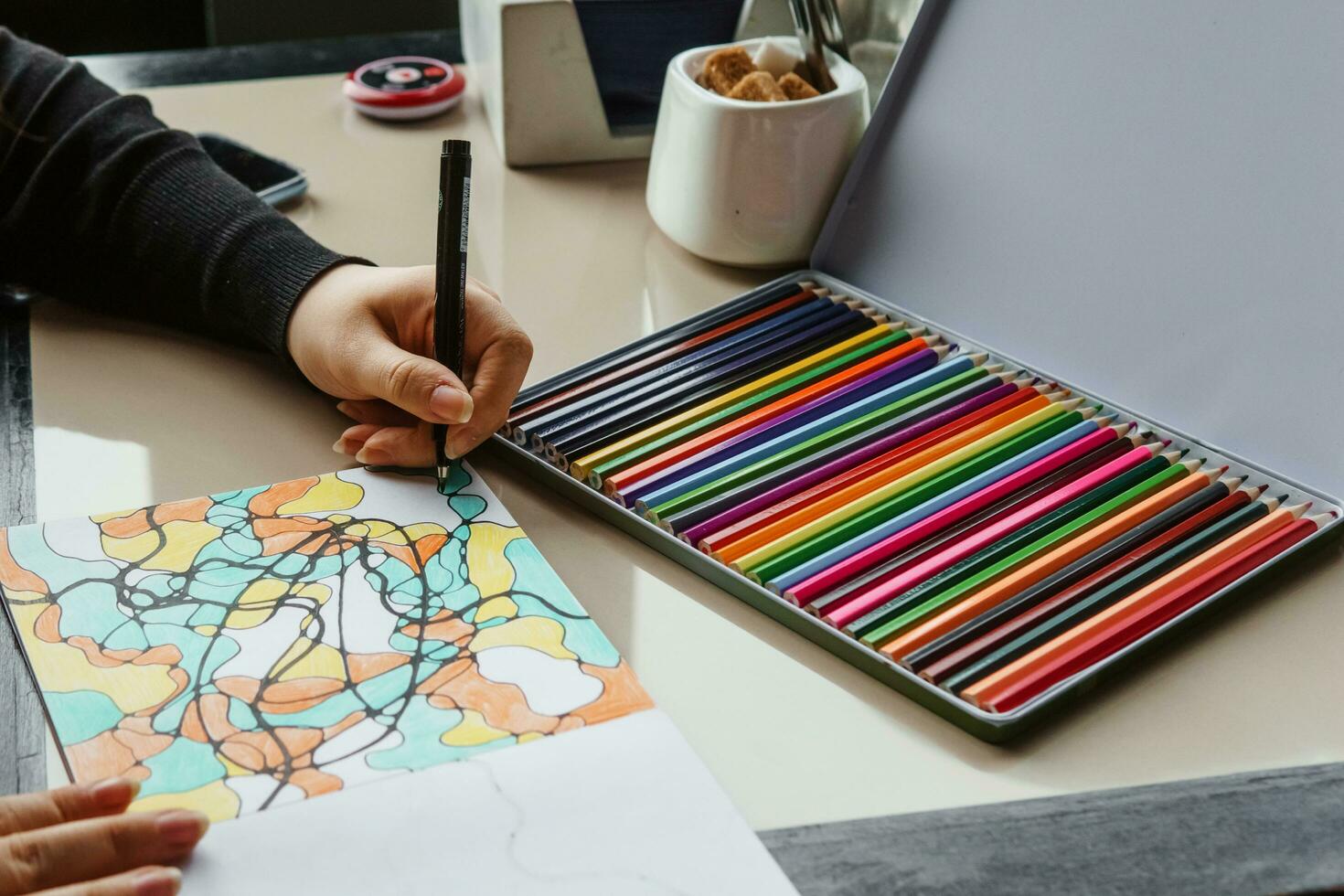 TVER, RUSSIA - FEBRUARY 11, 2023. a young woman draws neurography at a table at a psychological session, a neurographic resunok with a pencil to remove oranicheniy, art therapy photo