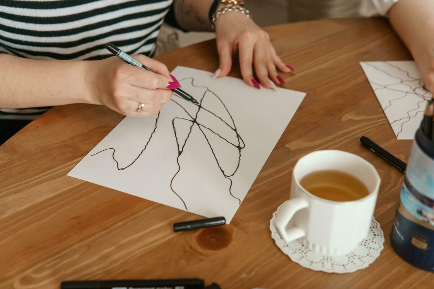 TVER, RUSSIA - FEBRUARY 25, 2023. Woman draws neurographics at table photo