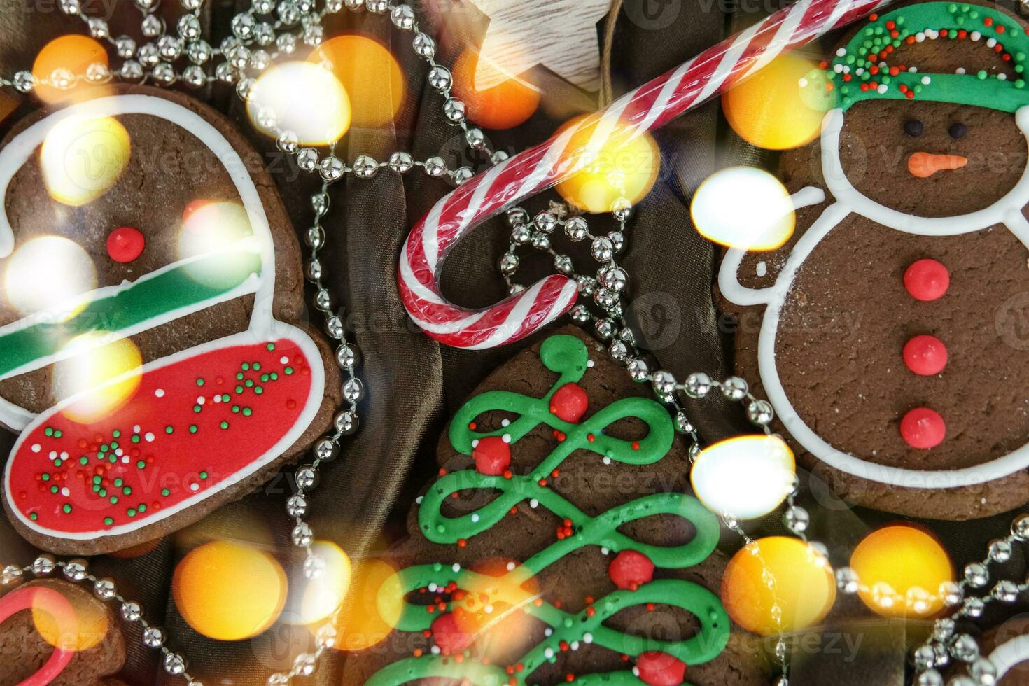 Banner for Christmas and New Year gingerbread. Christmas trees, toys, snowmen, garlands on a background of brown silk fabric. Bright bokeh. photo