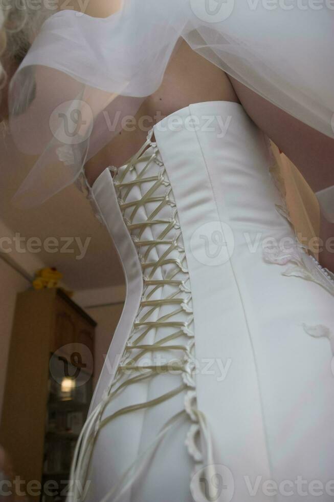 The bride's corset in a white long wedding dress photo