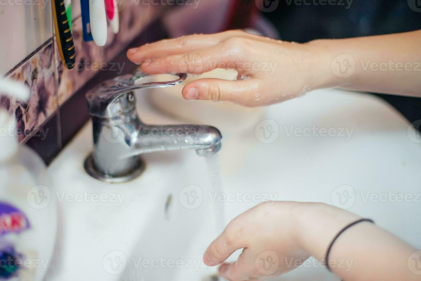 child closes faucet with flowing water. Saving water. cleaning hand to stop spread of Covid-19,Coronavirus pandemic photo