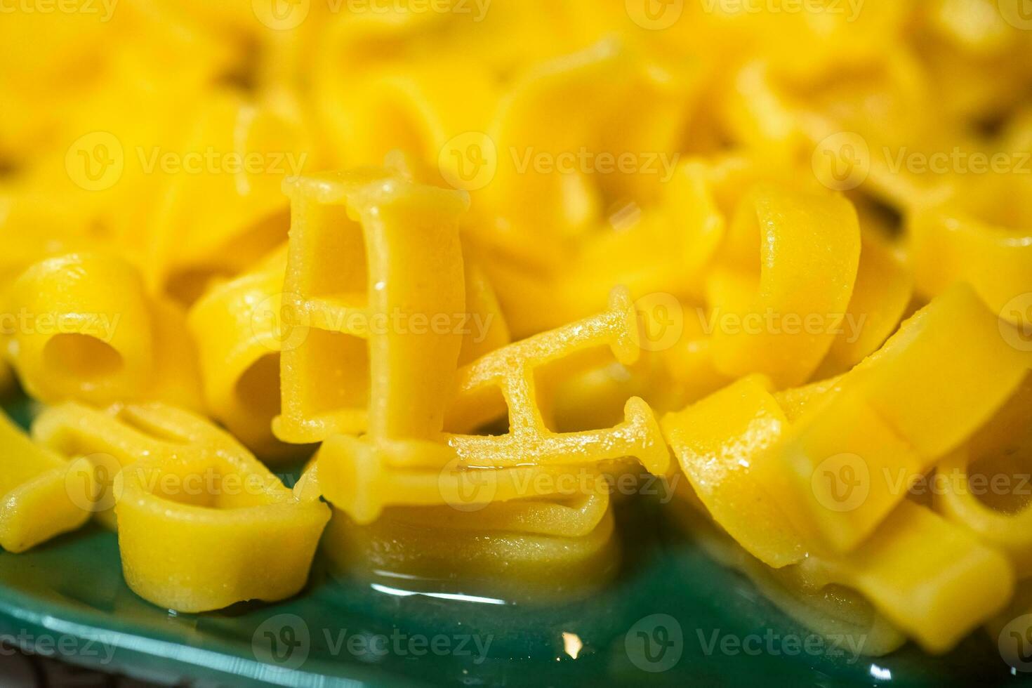 macaroni alphabet letters on a green plate. photo