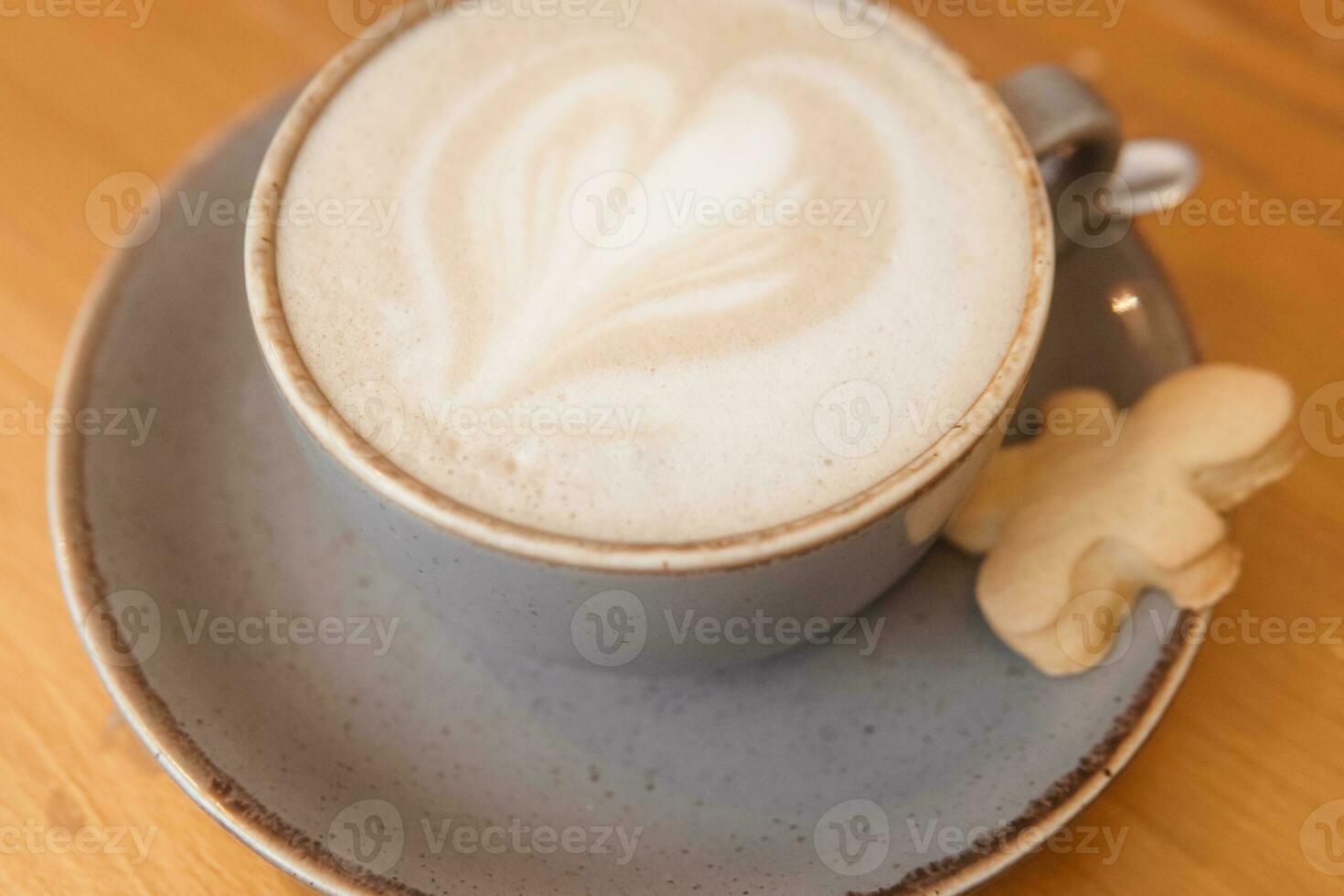 Coffee on a wooden table in a cafe, drawings on coffee. photo