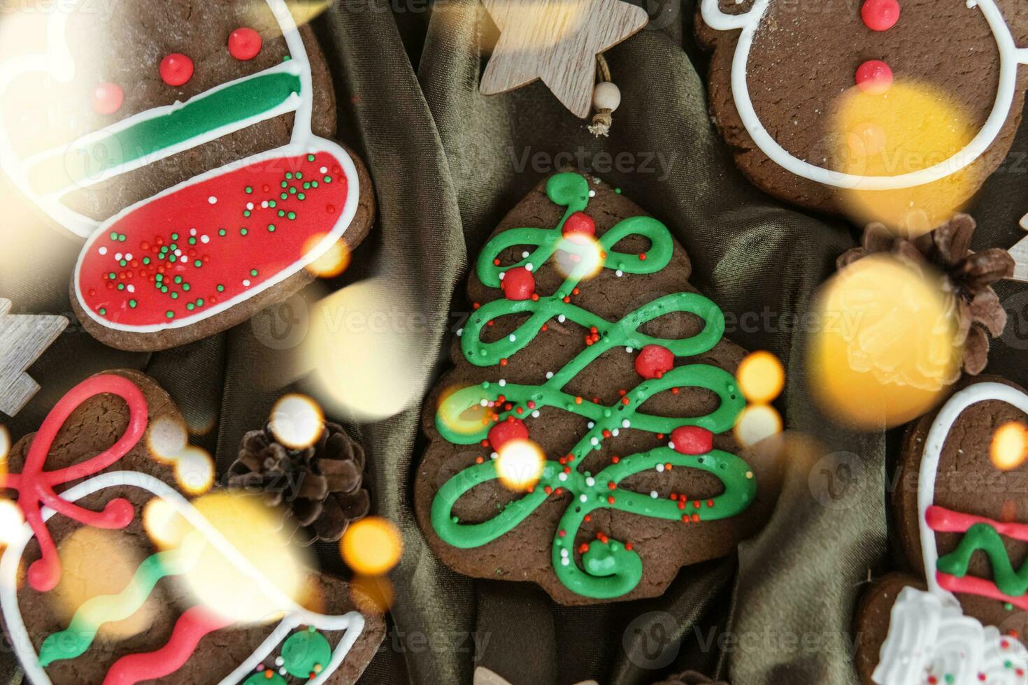 Banner for Christmas and New Year gingerbread. Christmas trees, toys, snowmen, garlands on a background of brown silk fabric. Bright bokeh. photo