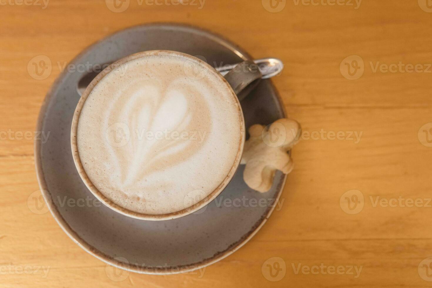 Coffee on a wooden table in a cafe, drawings on coffee. photo