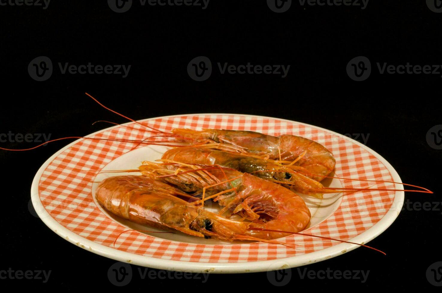 Tres grande camarón en un plato con un a cuadros modelo foto