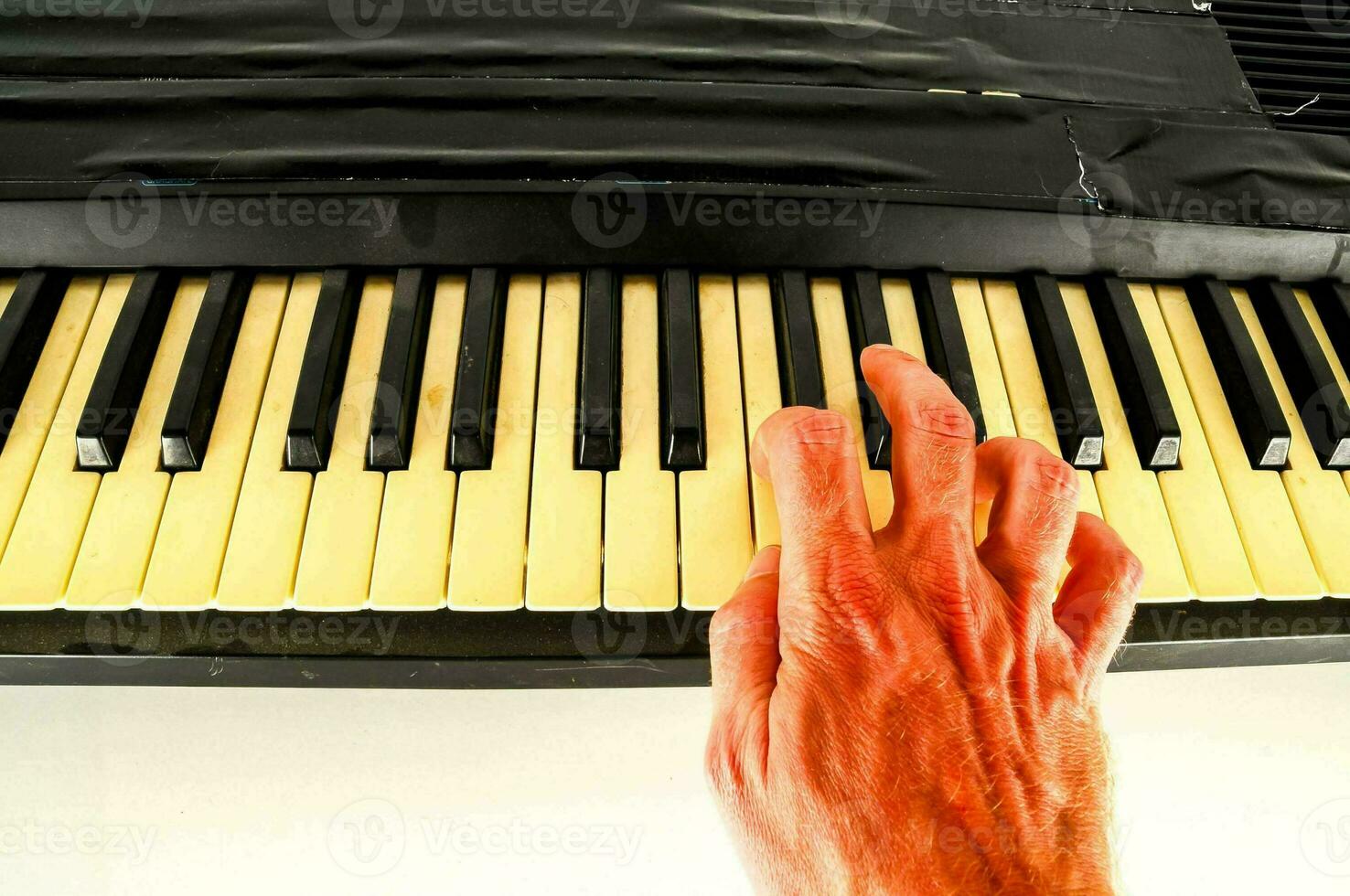 a hand is touching the keys of a piano photo