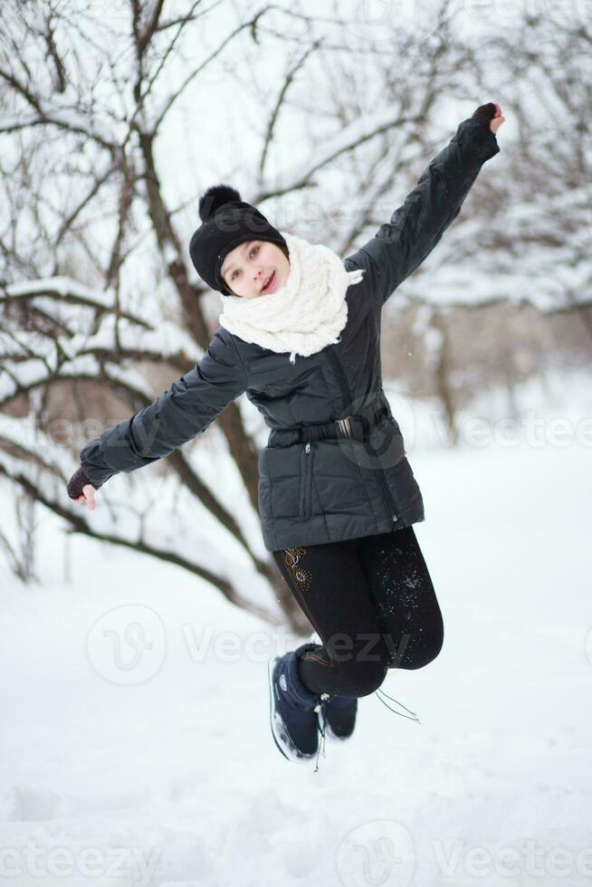 The girl jumped over a snowdrift. photo