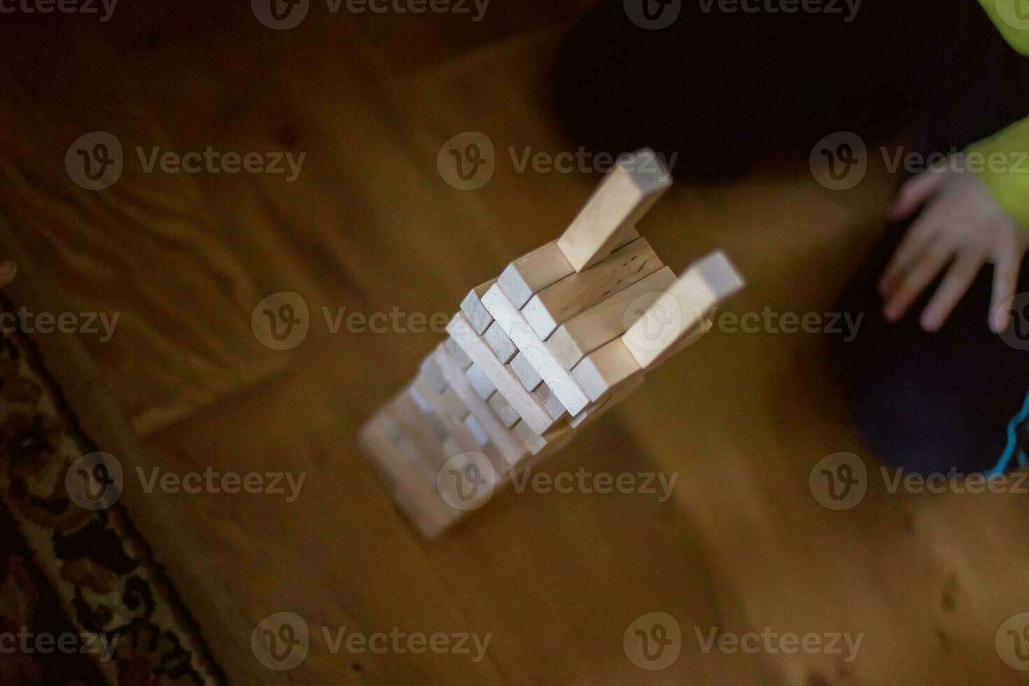 The child builds a tower of wooden blocks. Soft focus photo