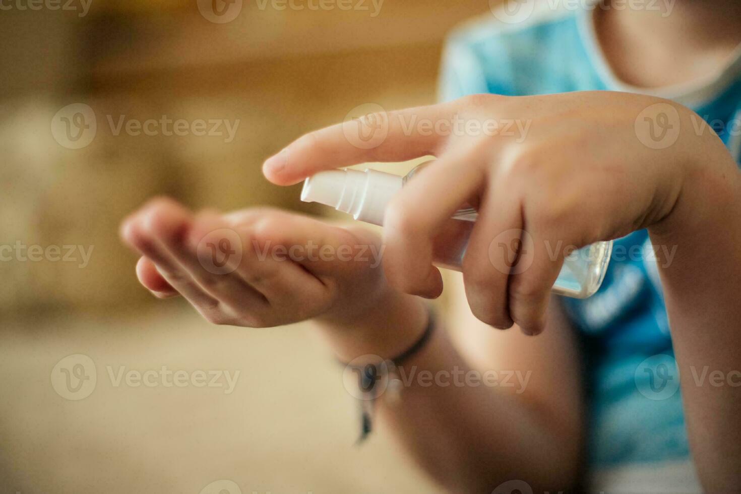 sanitizer in hands of child. Hand treatment is disinfection tool. Destroying viruses from surface of skin. Safety at risk of contracting coronavirus. photo
