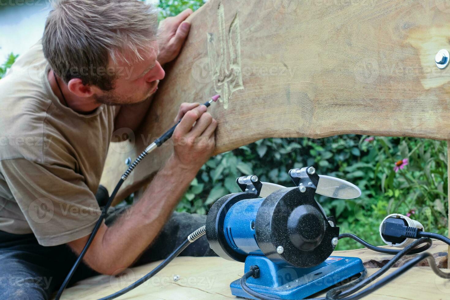 The man bends down to draw the coat of arms of Ukraine. photo