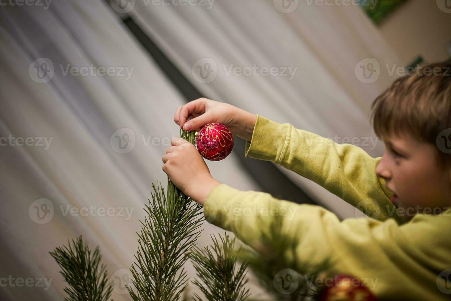 brothers decorate a Christmas tree in a country house before Christmas with simple balls and toys. Family leisure time together on Christmas evening and before the new year 2022 photo