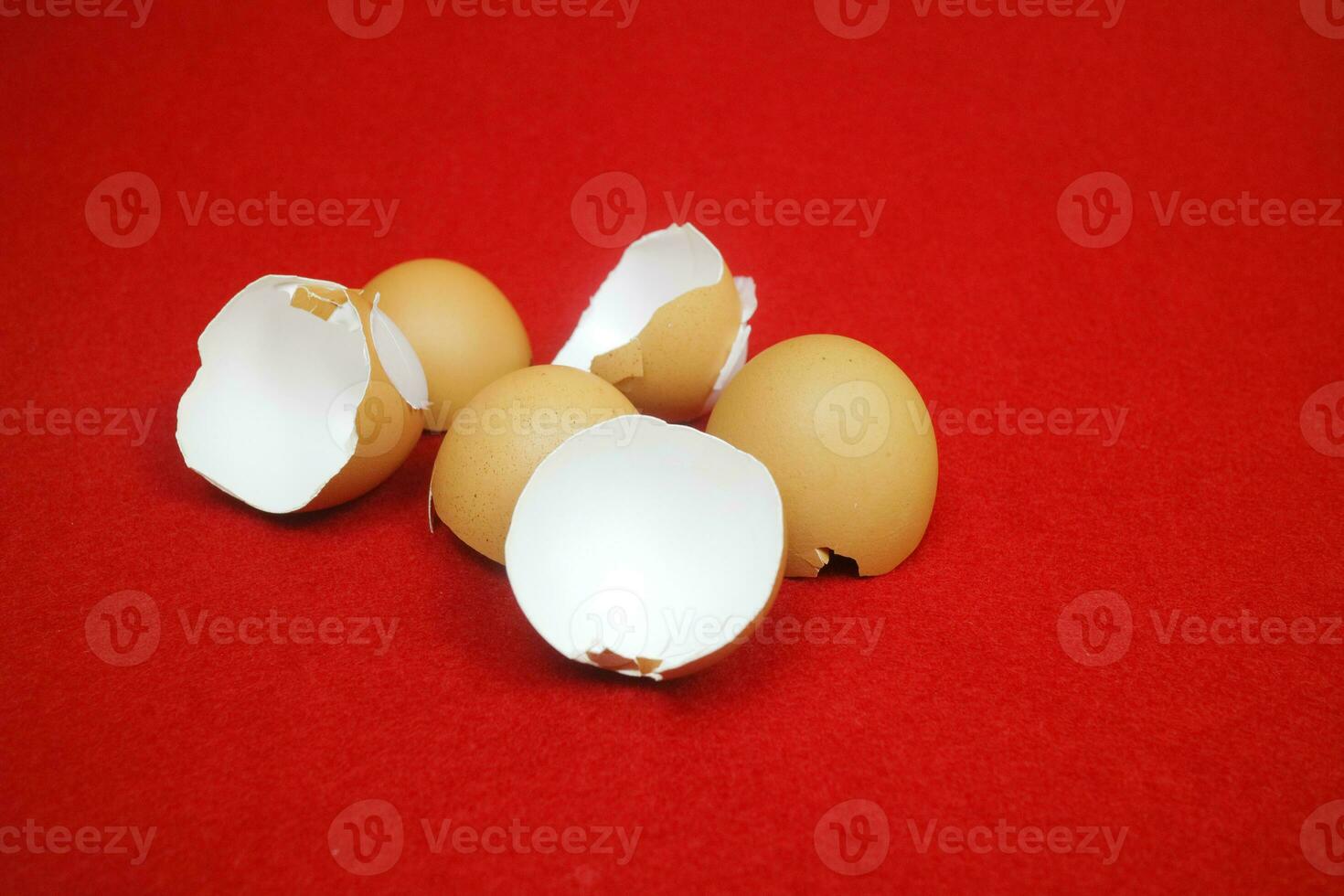 Several chicken egg shells, cracked and broken on red background photo