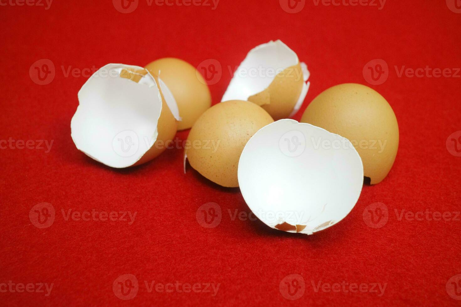 Several chicken egg shells, cracked and broken on red background photo