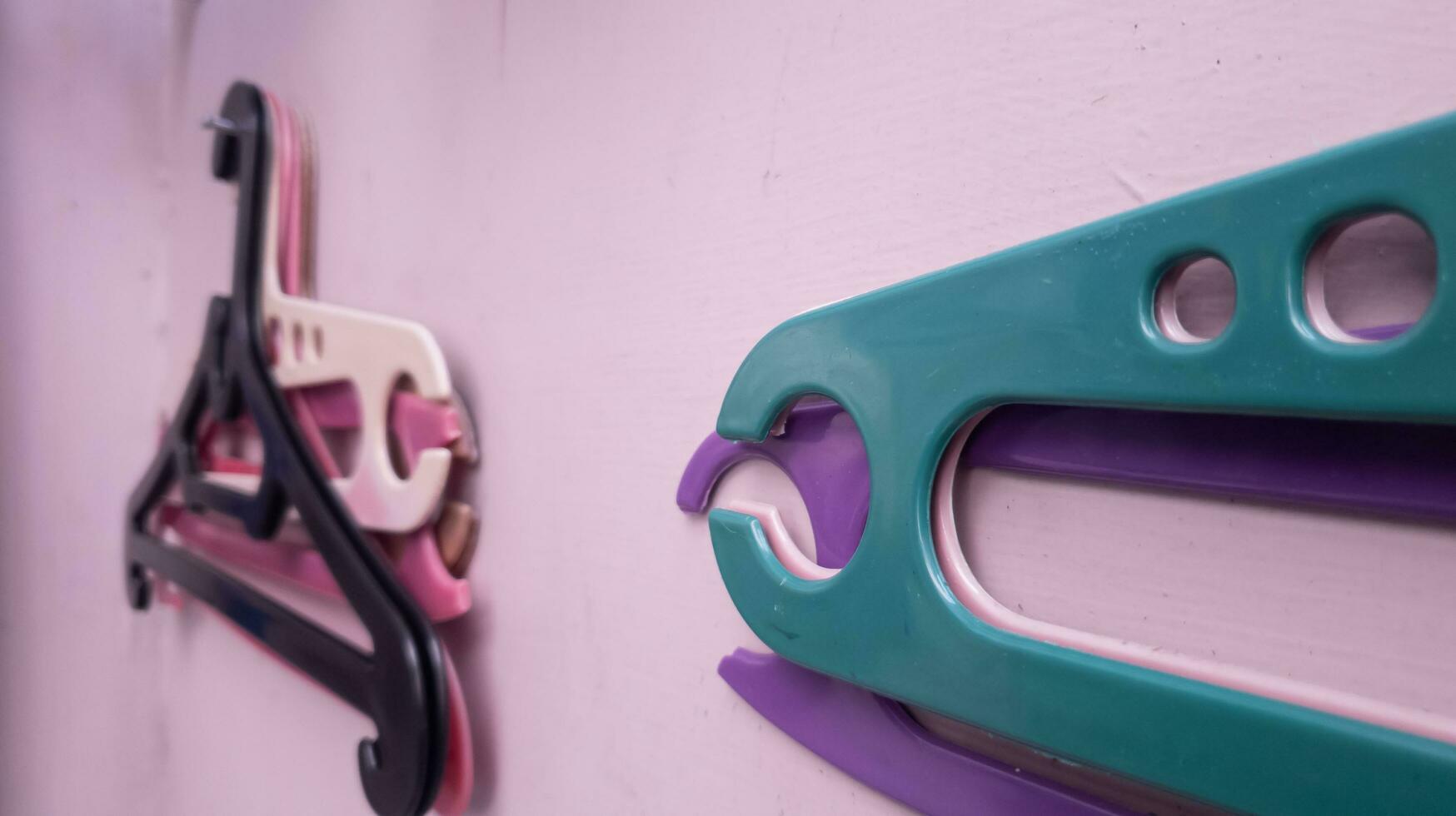 a clothes hanger hanging on a nail on a purple wall. selective focus photo