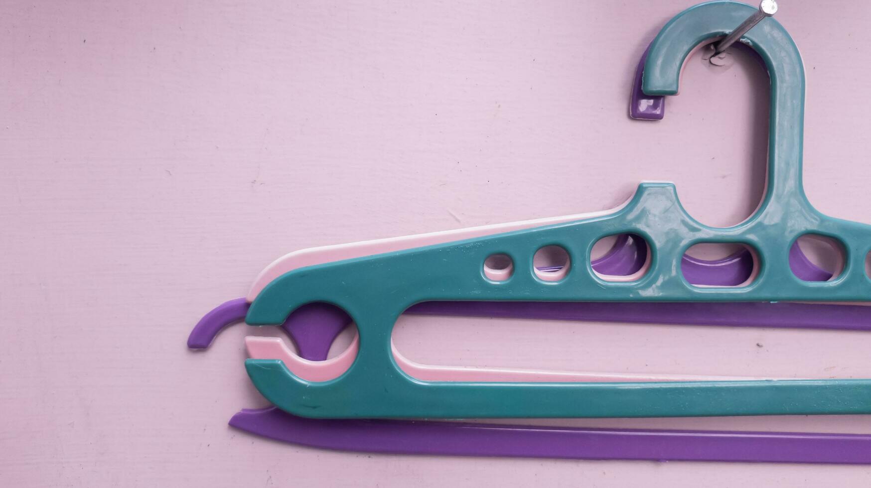 a clothes hanger hanging on a nail on a purple wall photo