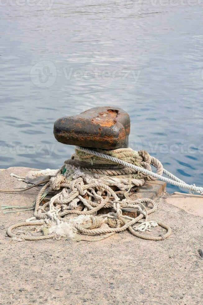 a large anchor and rope on the shore photo