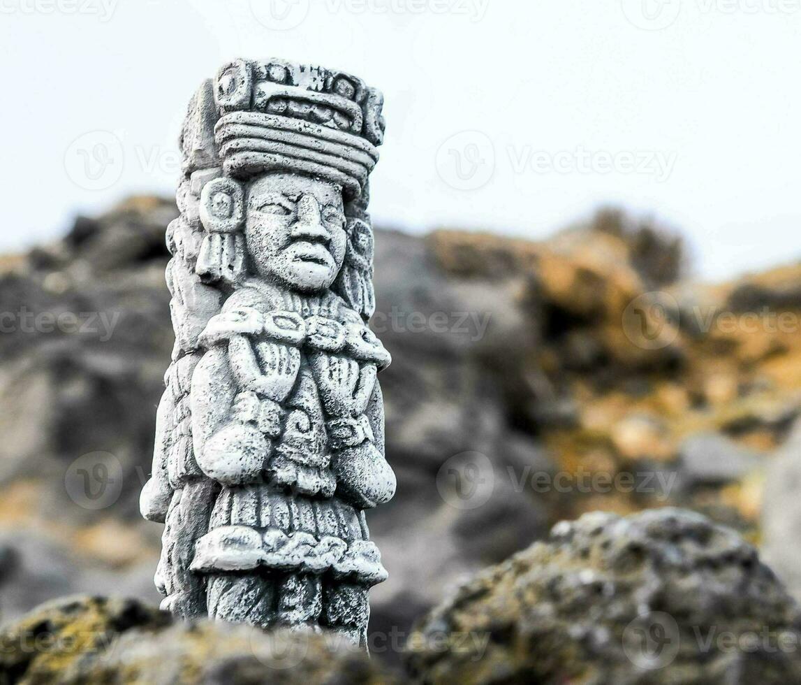 a statue of an ancient person on a rock photo