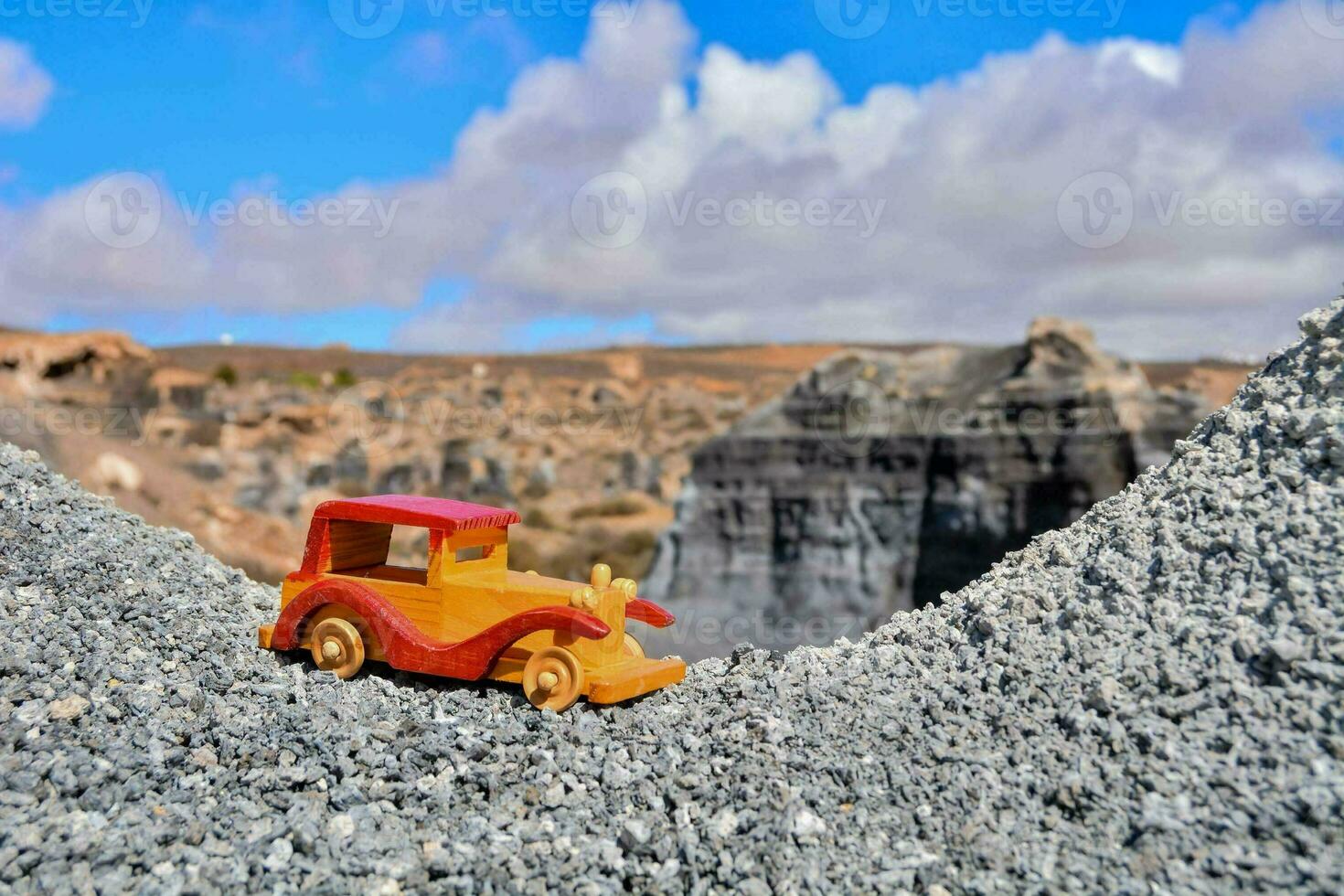 a toy car is sitting on top of a mountain photo
