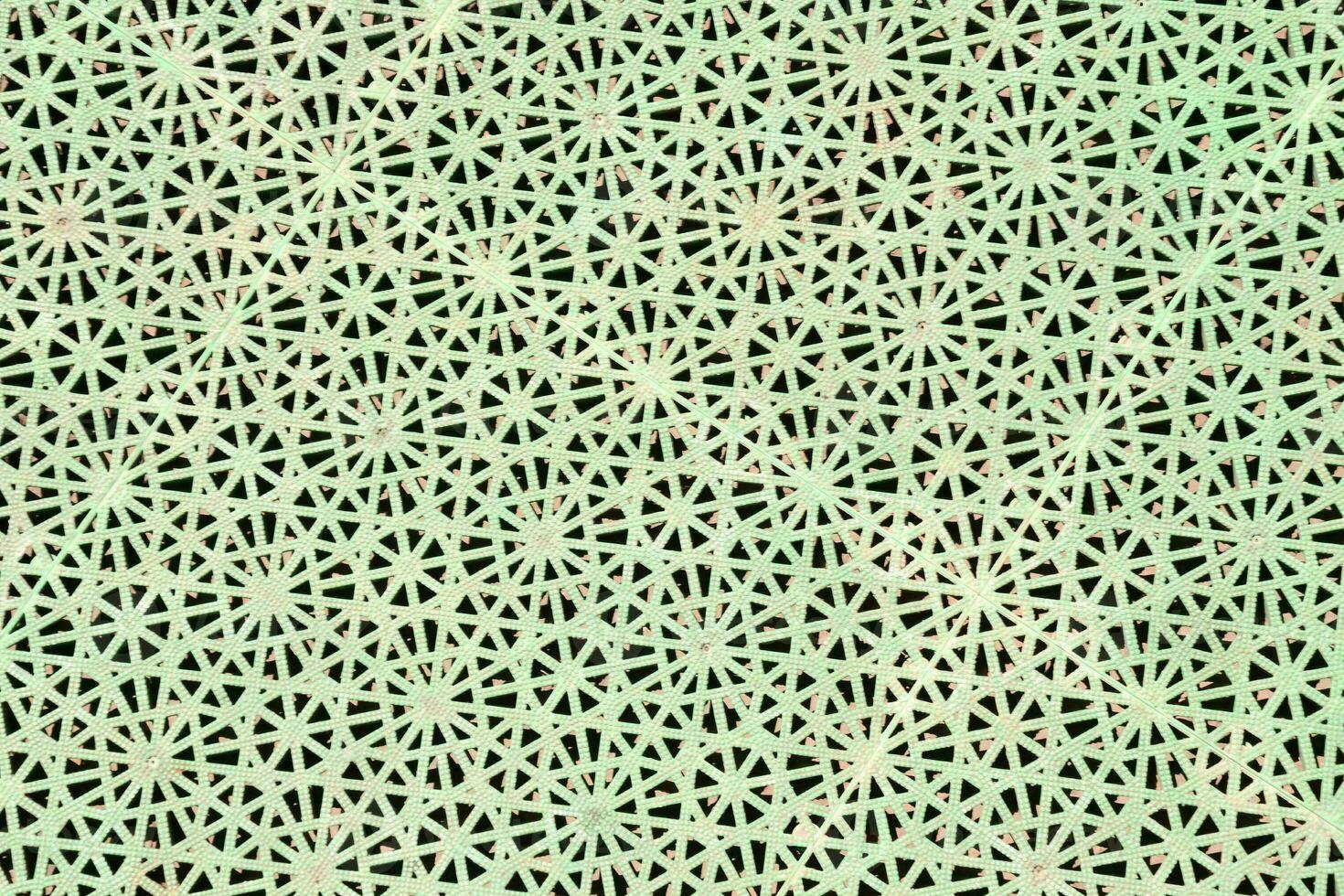 a green and white patterned background with holes photo