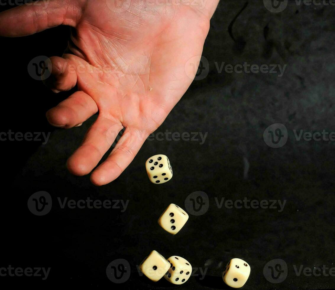 a person throwing dice on a black background photo