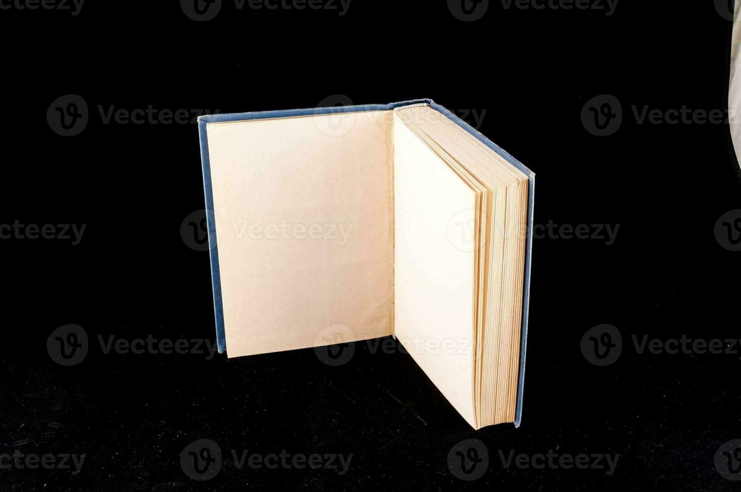 a book open on a black surface with a white object photo