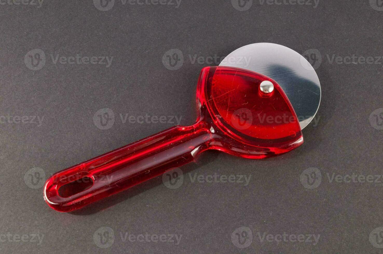 a red plastic pizza cutter photo